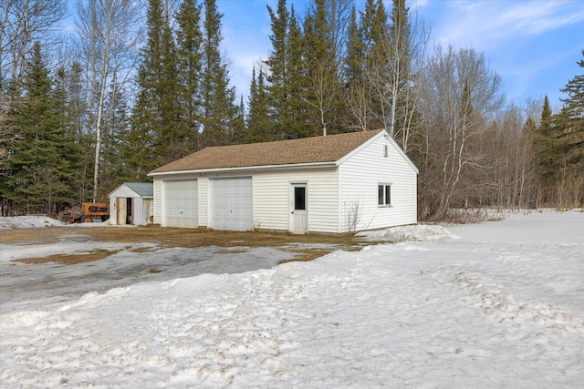 snow covered garage featuring a garage