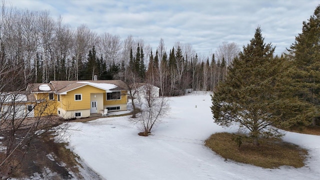 snowy aerial view with a wooded view