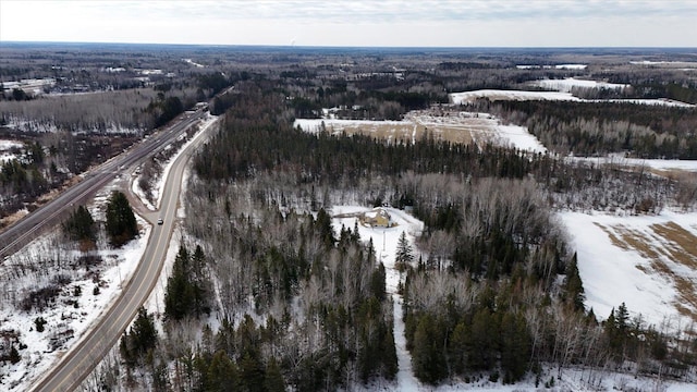 snowy aerial view featuring a wooded view