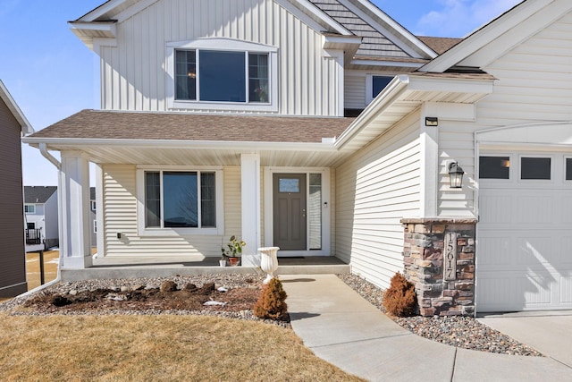 entrance to property featuring a porch, an attached garage, board and batten siding, and roof with shingles