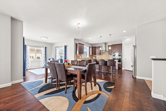 dining area with a textured ceiling, baseboards, and dark wood-style flooring