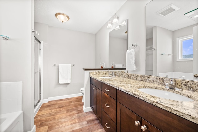 full bathroom with a sink, visible vents, wood finished floors, and a bath