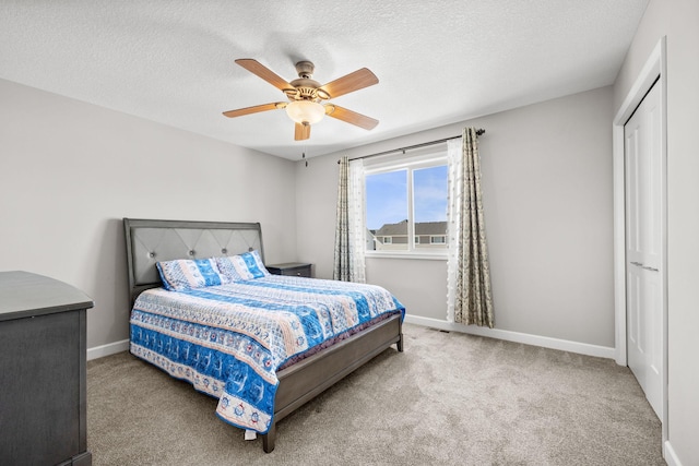 bedroom with ceiling fan, carpet, baseboards, and a textured ceiling