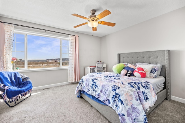 carpeted bedroom featuring ceiling fan, visible vents, baseboards, and a textured ceiling