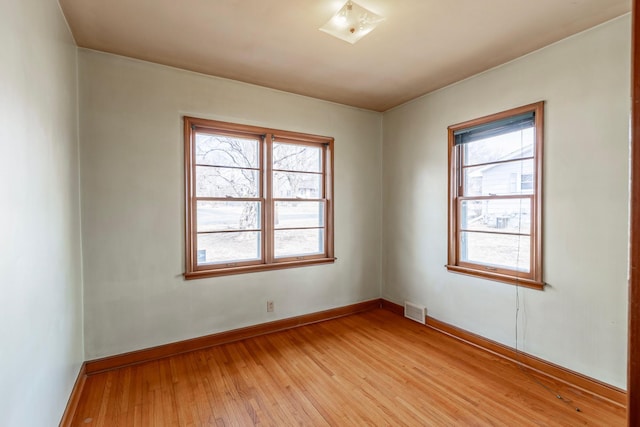 unfurnished room with visible vents, baseboards, and light wood-style floors