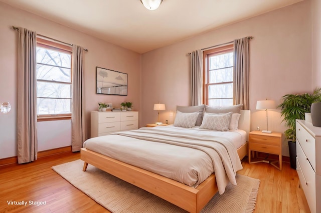 bedroom with light wood finished floors and baseboards