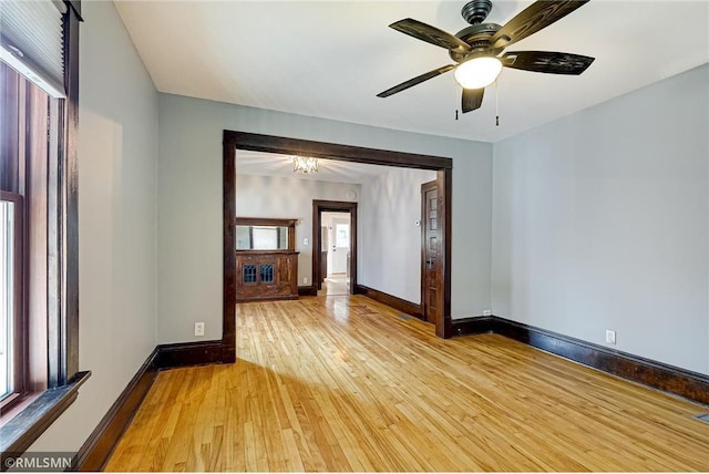 empty room featuring light wood finished floors, plenty of natural light, and baseboards