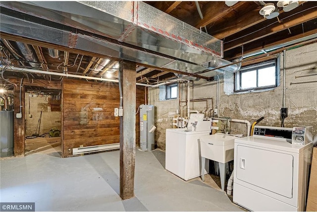 basement featuring separate washer and dryer, water heater, baseboard heating, and electric water heater