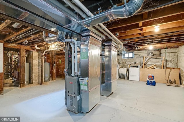 basement with gas water heater, heating unit, and washing machine and clothes dryer