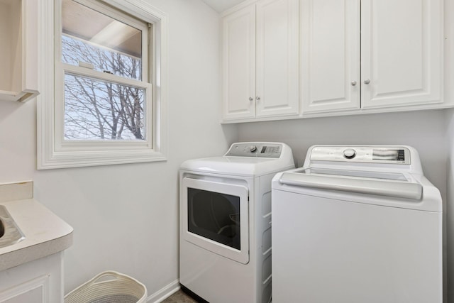 laundry room featuring baseboards, cabinet space, and washing machine and dryer