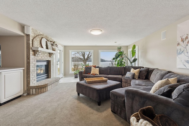 carpeted living room with visible vents, a textured ceiling, and a fireplace