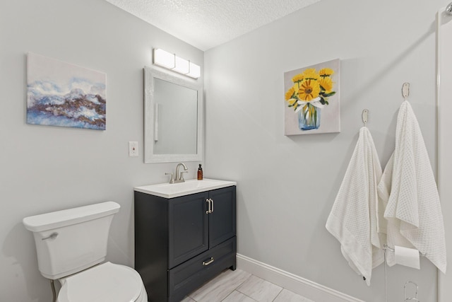 bathroom with baseboards, toilet, vanity, marble finish floor, and a textured ceiling