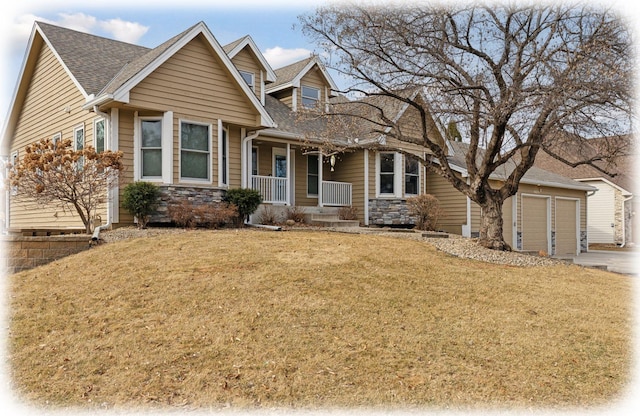 view of front facade with stone siding, a porch, a shingled roof, an attached garage, and a front yard