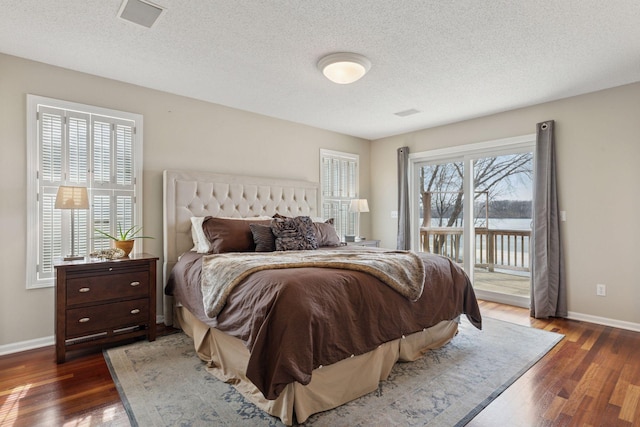 bedroom with access to exterior, baseboards, wood-type flooring, and a textured ceiling