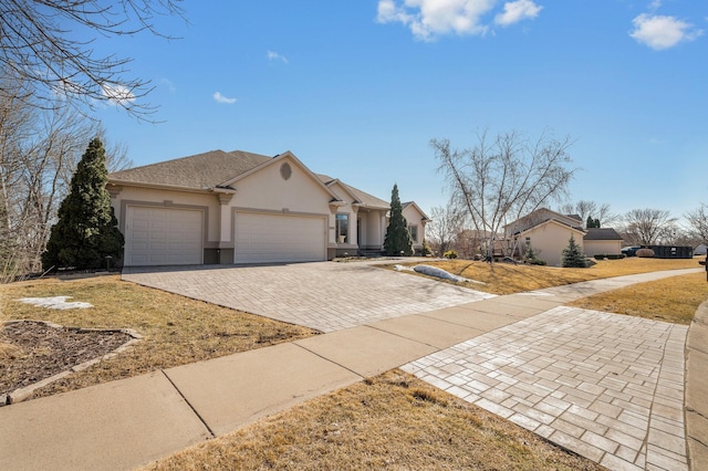 ranch-style home with stucco siding, a shingled roof, decorative driveway, and a garage