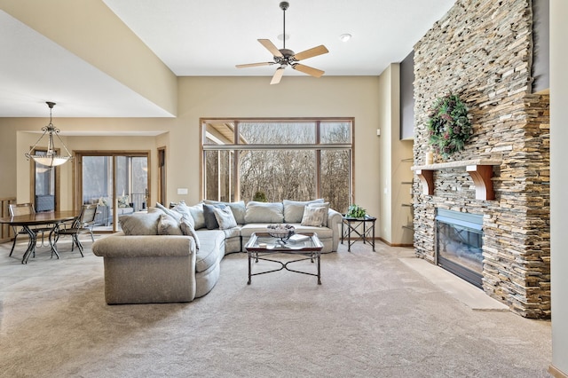 living room featuring carpet flooring, plenty of natural light, a ceiling fan, and a fireplace