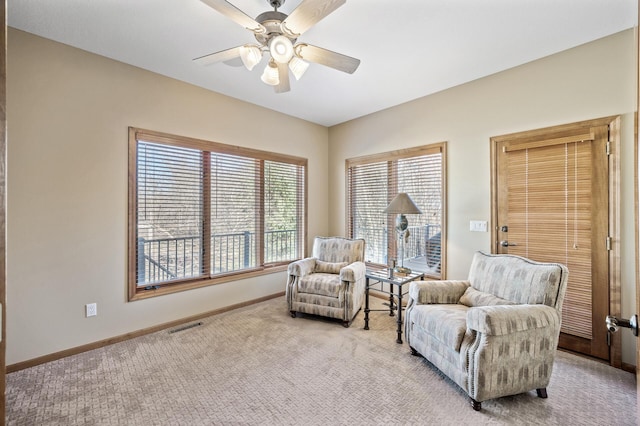 sitting room with visible vents, light colored carpet, baseboards, and ceiling fan