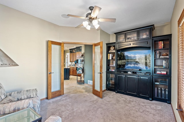 living area with visible vents, baseboards, light colored carpet, french doors, and a ceiling fan