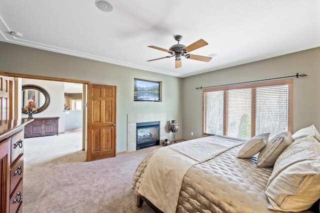 bedroom with carpet flooring, a fireplace, crown molding, and ceiling fan