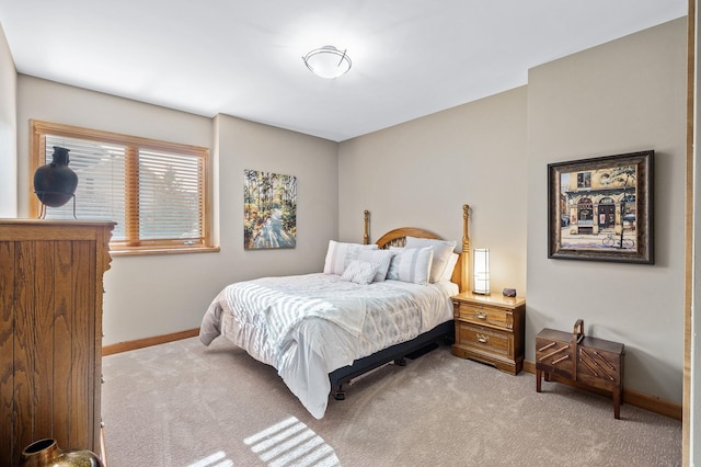 bedroom with baseboards and light colored carpet