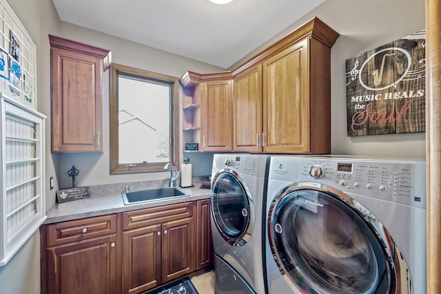 clothes washing area with a sink, cabinet space, and independent washer and dryer