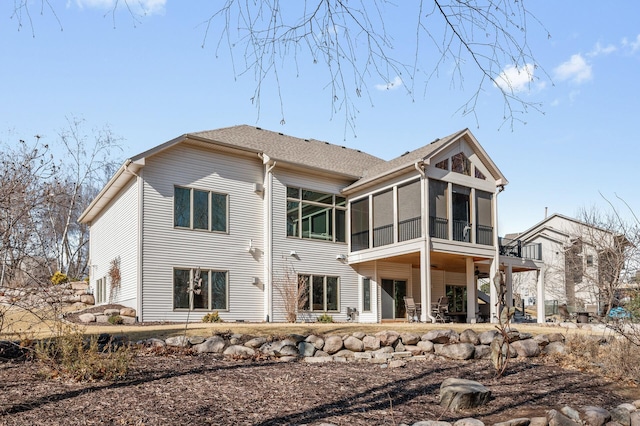 back of property featuring a shingled roof and a sunroom