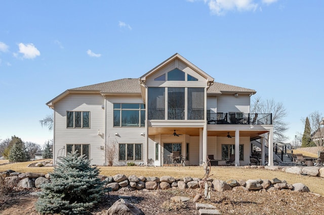 back of property with a ceiling fan, roof with shingles, a wooden deck, a sunroom, and stairs