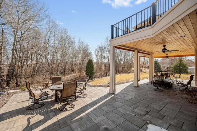 view of patio with outdoor dining area, a balcony, and ceiling fan