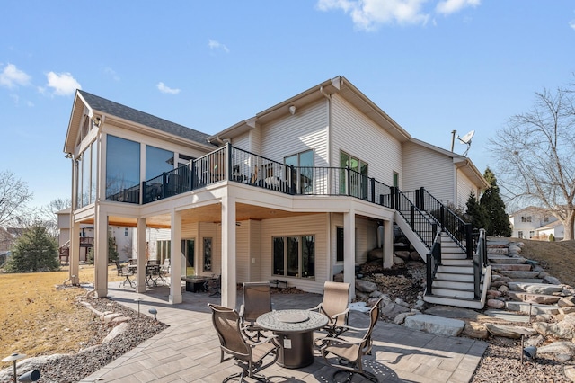 back of house with stairway, a patio, outdoor dining area, and a deck