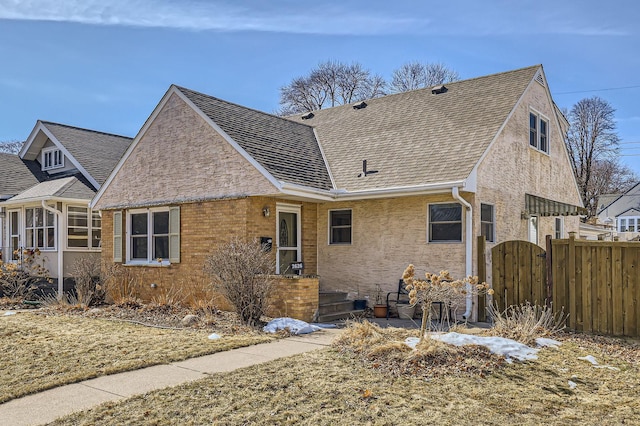 view of front of home featuring stucco siding, a shingled roof, fence, and a gate