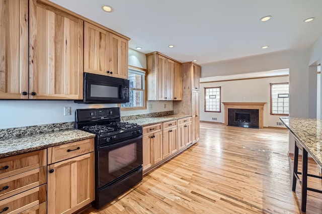 kitchen with open floor plan, recessed lighting, black appliances, and light wood-type flooring