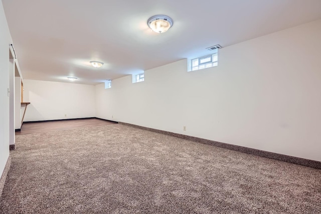 below grade area featuring visible vents, carpet floors, and baseboards