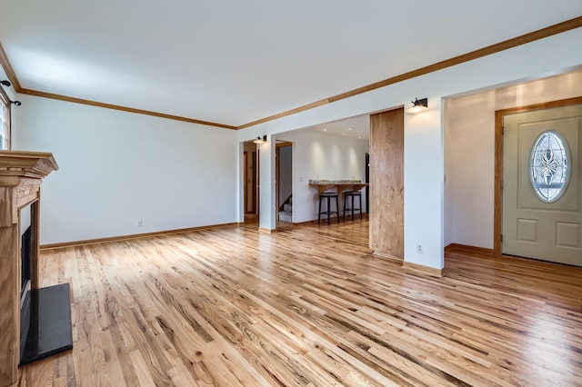 foyer with ornamental molding, baseboards, and wood finished floors