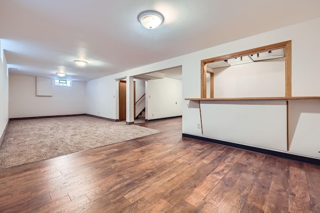 basement with stairway, baseboards, and wood finished floors