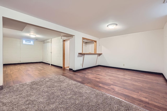 basement featuring baseboards and wood finished floors