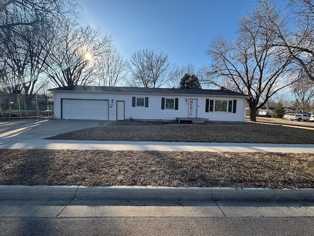 view of front of property featuring concrete driveway, an attached garage, and fence