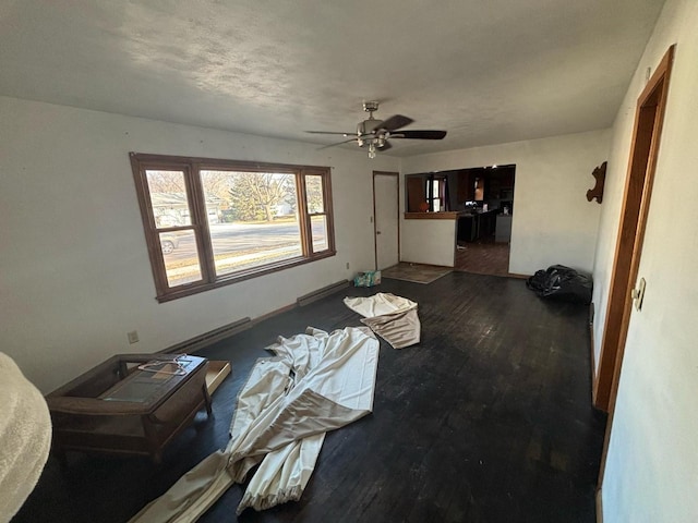 living area featuring a baseboard heating unit, ceiling fan, and wood finished floors