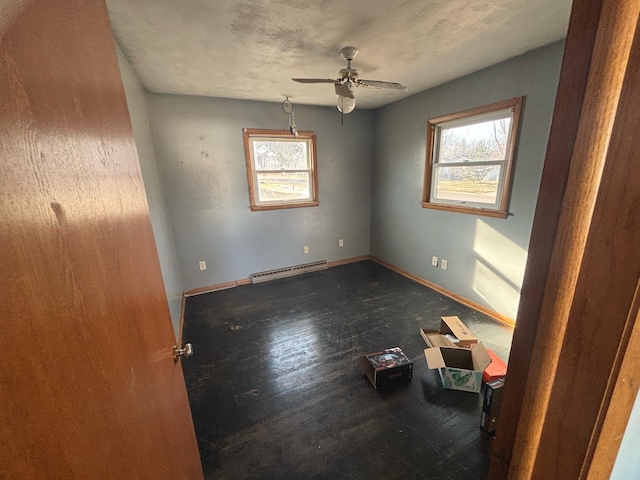 unfurnished room featuring wood finished floors, a baseboard radiator, baseboards, and ceiling fan