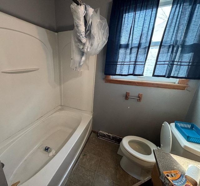 bathroom featuring tile patterned flooring, toilet, vanity, and a wealth of natural light