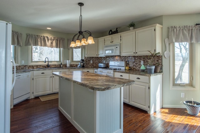 kitchen featuring tasteful backsplash, white appliances, dark wood-type flooring, and a sink