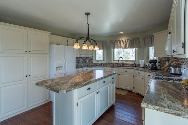 kitchen featuring dark wood-style floors, white appliances, a center island, and a sink