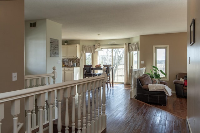 living area featuring visible vents, baseboards, and dark wood-style floors