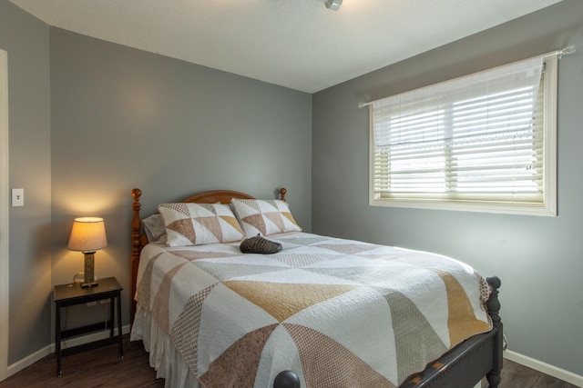 bedroom with wood finished floors and baseboards