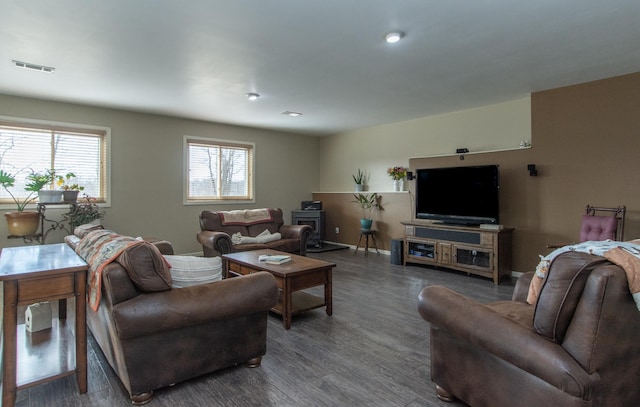 living room featuring visible vents, baseboards, and wood finished floors