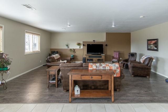 living room with visible vents, baseboards, and wood finished floors
