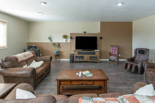 living area with visible vents, baseboards, and wood finished floors