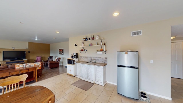 kitchen with visible vents, light tile patterned flooring, recessed lighting, freestanding refrigerator, and tasteful backsplash