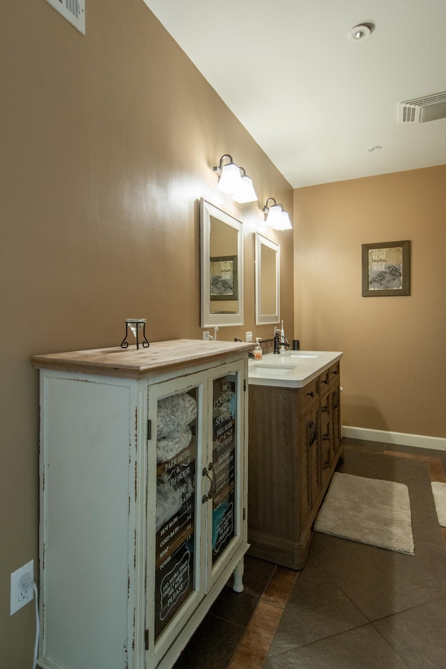 bathroom with vanity, baseboards, visible vents, and tile patterned flooring