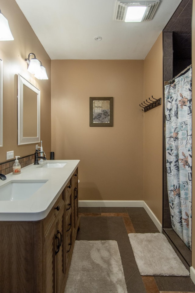 full bath featuring baseboards, visible vents, and a sink