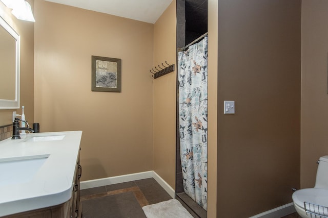 full bathroom featuring a shower with shower curtain, toilet, baseboards, and a sink
